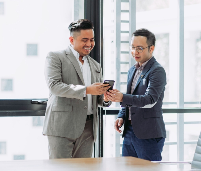 two men sharing info on a phone